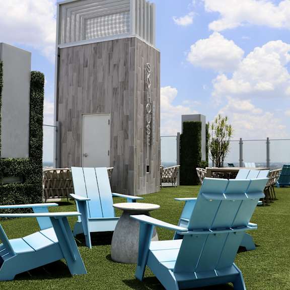 a row of blue lounge chairs and tables on a roof top patio with a building