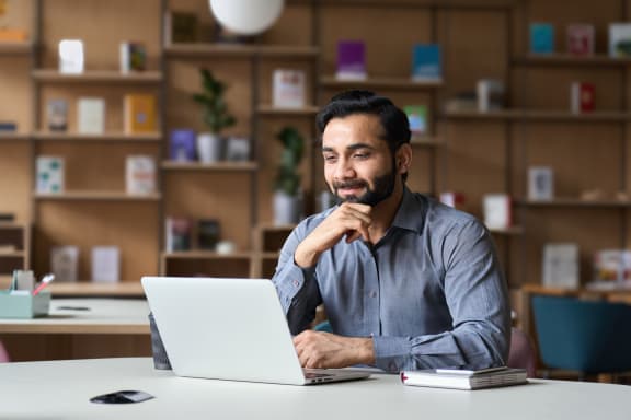 a man sitting at a table with a laptop
