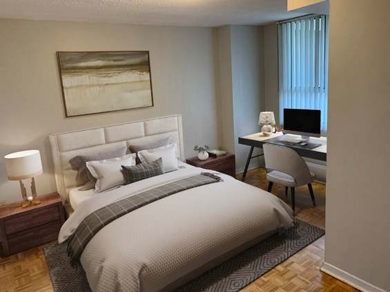 A bedroom with a large bed and a desk with a computer.