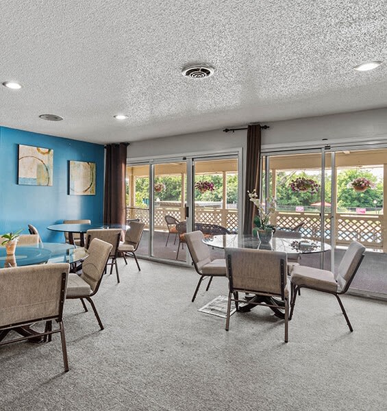 a dining room with tables and chairs and windows