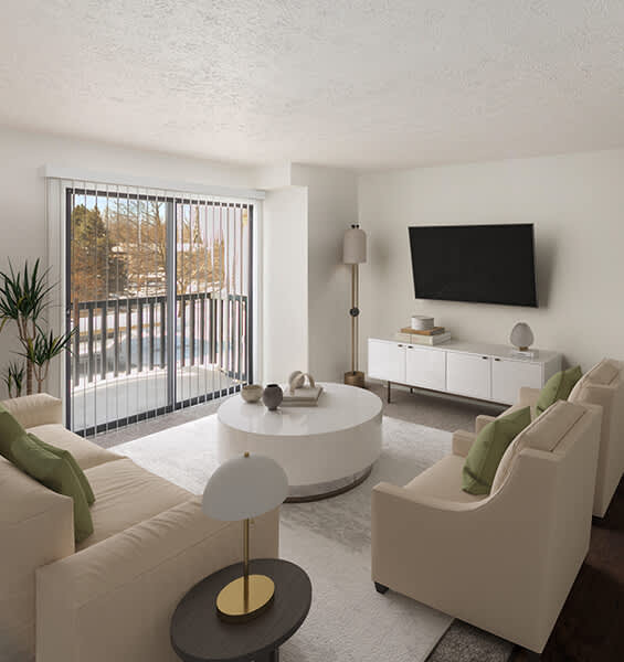 A modern living room with a white sofa, a round table, and a flat-screen TV mounted on the wall.