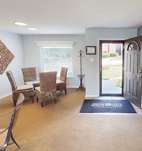 a living room with a table and chairs and a door