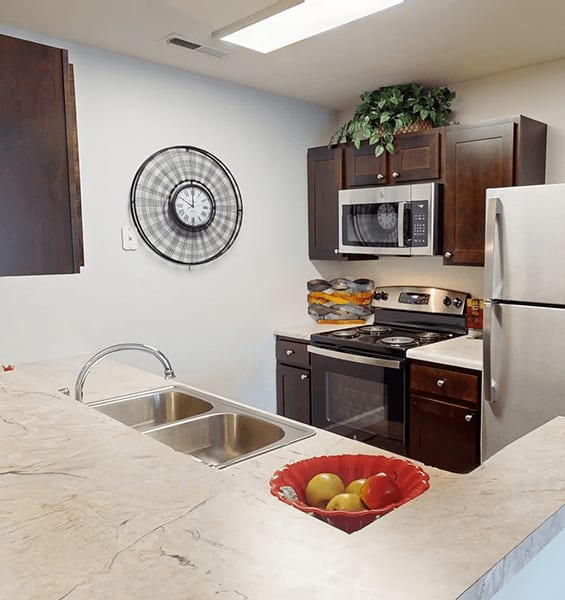 A kitchen with a stove, oven, microwave, and refrigerator.