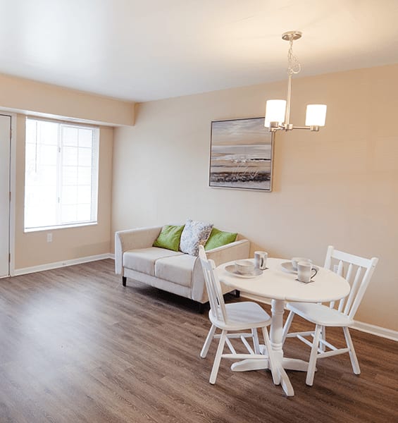 A living room with a white table and chairs.