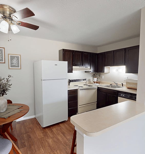 A kitchen with a white refrigerator and wooden floors.