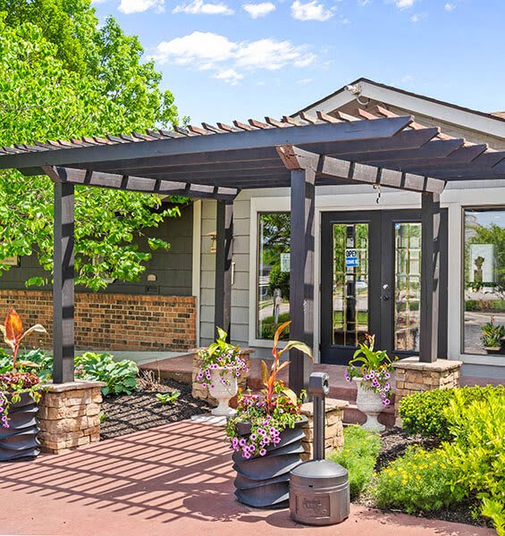 a patio with a pergola and some potted plants