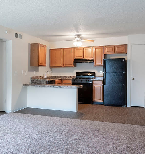 A kitchen with black appliances and wooden cabinets.