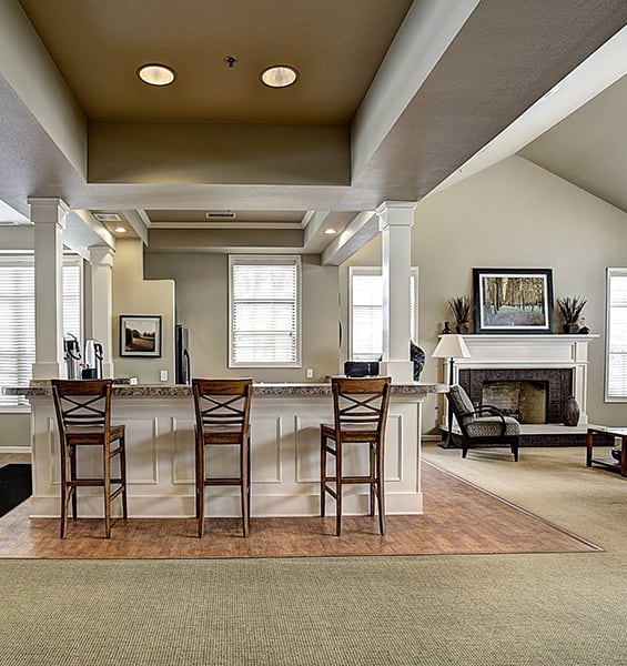 a large living room with a bar and a fireplace