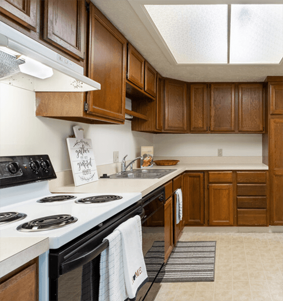 A kitchen with a white stove top oven and black stove burners.