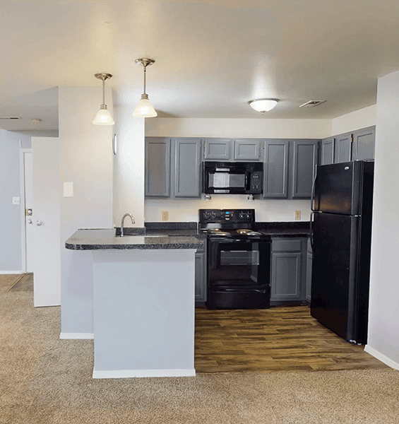 A kitchen with black appliances and a granite counter top.