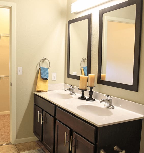 a bathroom with two sinks and two mirrors