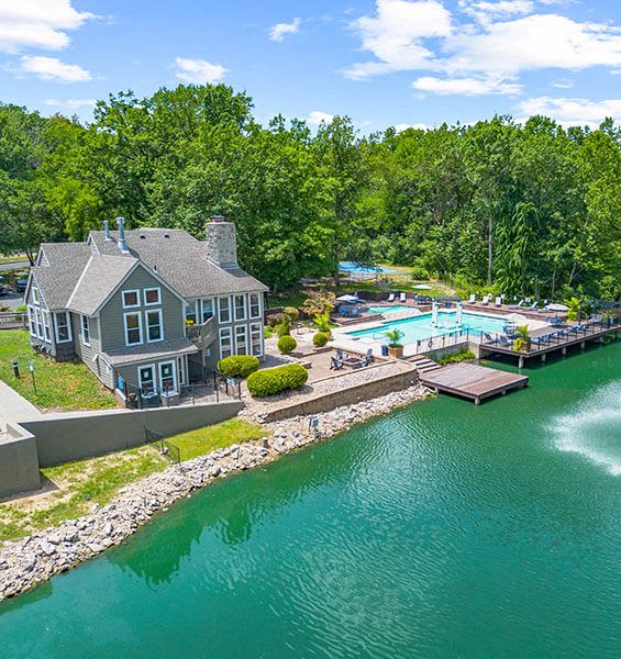 a large house with a pool and a dock on the water