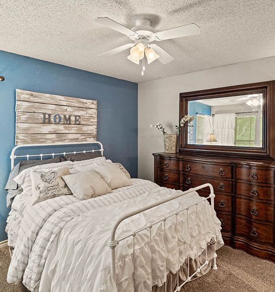 a bedroom with a bed and a ceiling fan