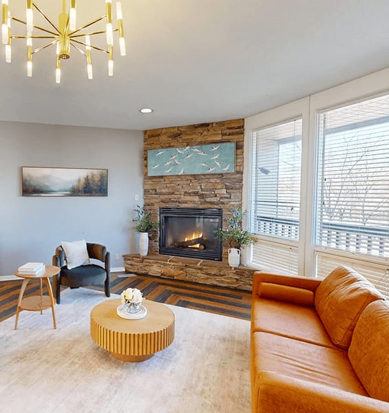A living room with a fireplace and a painting on the wall.