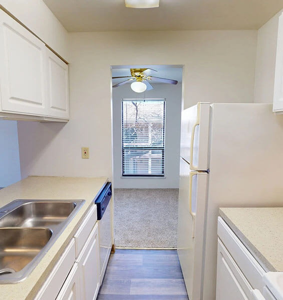 A kitchen with white cabinets and a stainless steel sink.