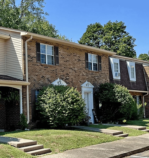 A brick house with a white door and windows.