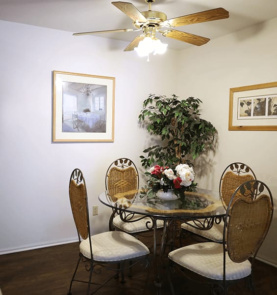 a bedroom with a ceiling fan and a bed with a blue and white comforter