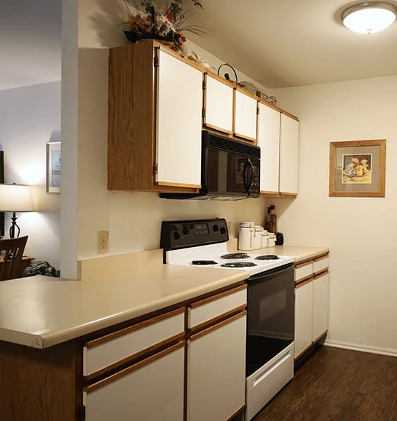 a kitchen with white cabinets and a stove and a microwave