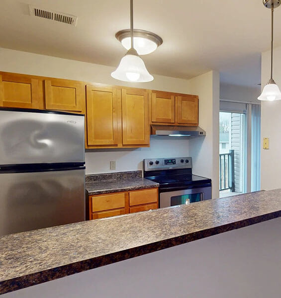 A kitchen with wooden cabinets and a granite counter.