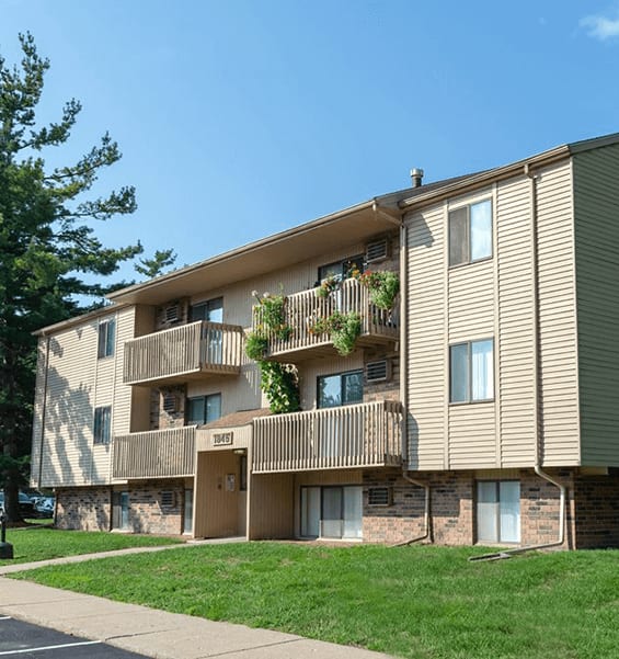 A beige apartment building with balconies and windows.
