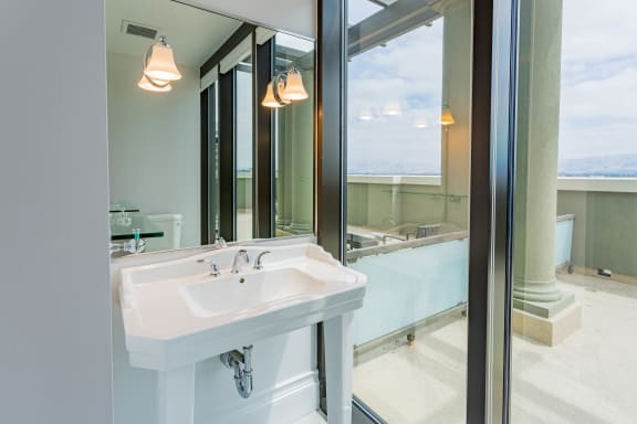 a bathroom with a white sink and a large mirror at Vendome Place, San Jose, CA