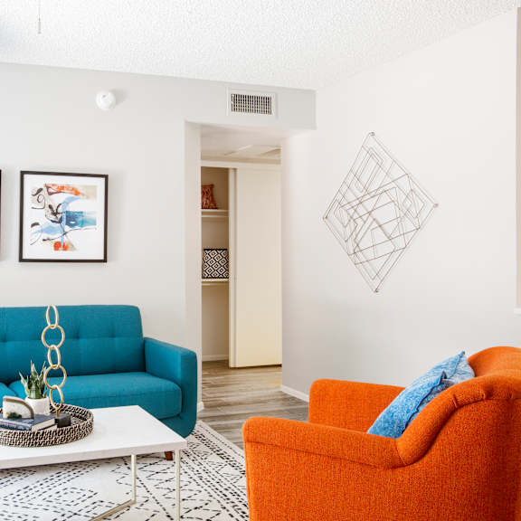 A living room with a blue couch, a white coffee table, and a lamp.