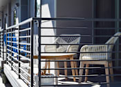 Thumbnail 5 of 5 - Two chairs and a table are on a balcony.