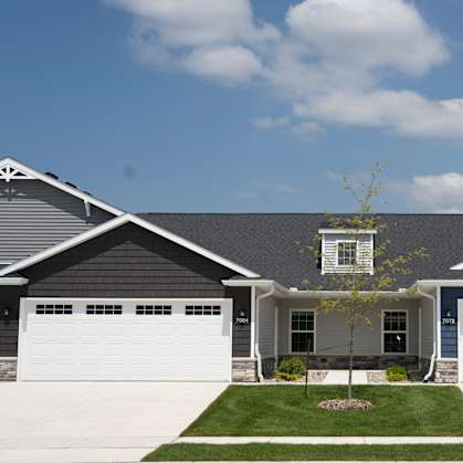 a house with two garage doors and a lawn