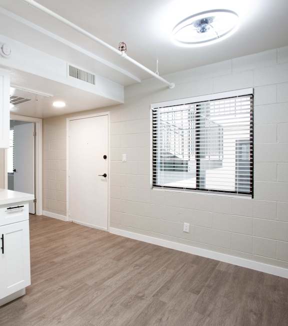 A room with a ceiling fan and wooden flooring.