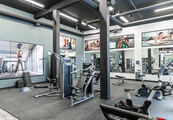 A gym with a variety of equipment including treadmills, weights, and exercise machines.at Skyway Apartments, Calgary, AB T3B 5V6
