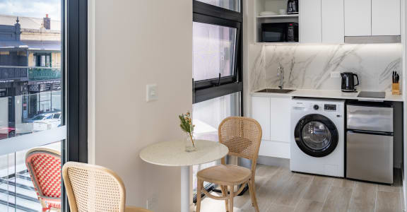 a living room with a table and chairs and a washing machine