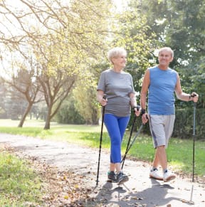 two women on cross country skis on a path in a park