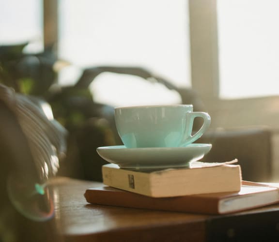 a cup of coffee on top of books on a table