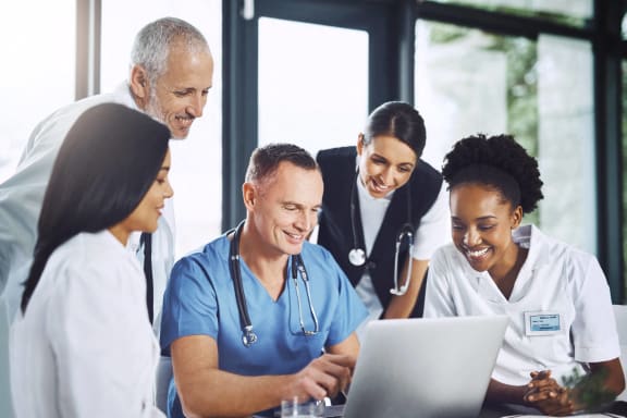a group of doctors shaking hands with a patient in a hospital