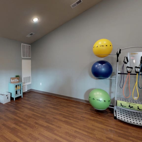 a workout room in a home with a wood floor and gray walls
