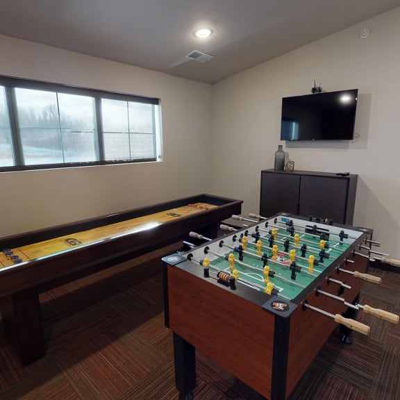a game room with a foosball table and a television