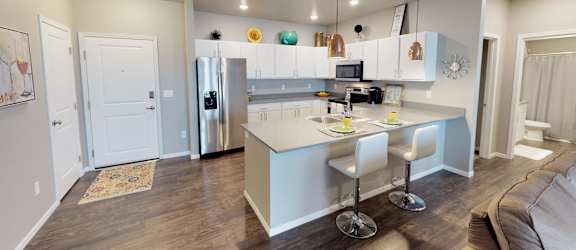 a kitchen with a blue island and white cabinets at Upscale Living at the Grand off 45th, Fargo, ND