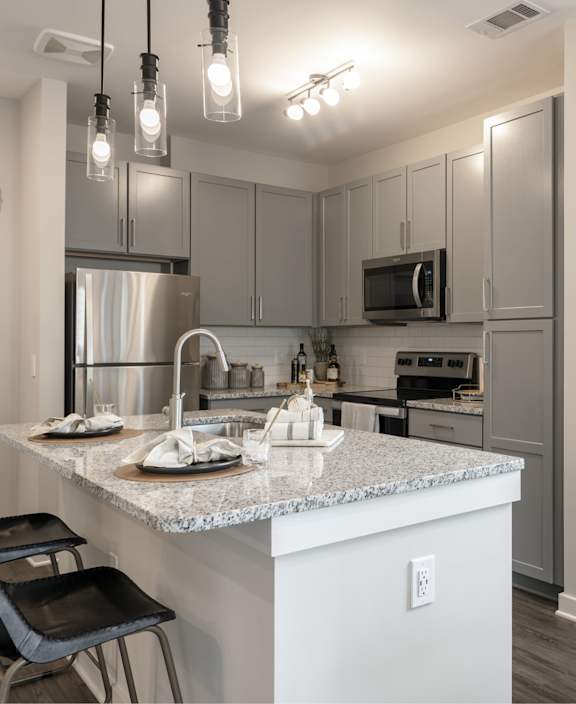 A modern kitchen with a marble island and stainless steel appliances.