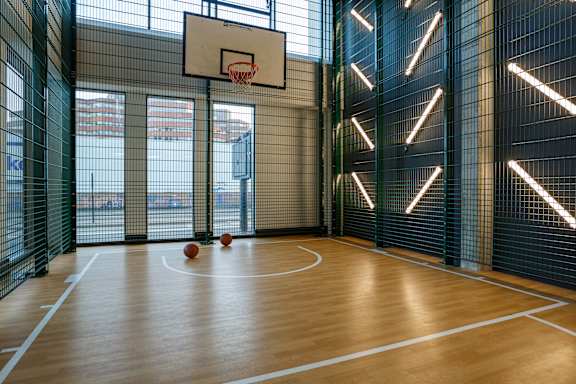 a basketball court in a gym with basketballs on the floor