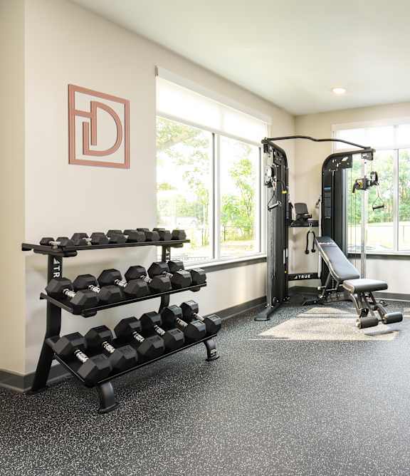 A man and a woman are working out on exercise bikes in a gym.