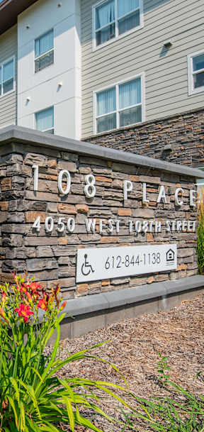 A building with a sign that says 108 Place in front of it.