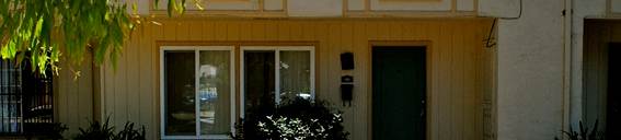A yellow apartment community with four windows and one door a walkway to the entrance of Prodesse Property Group 102 Poas Circle San Jose, CA 95116
