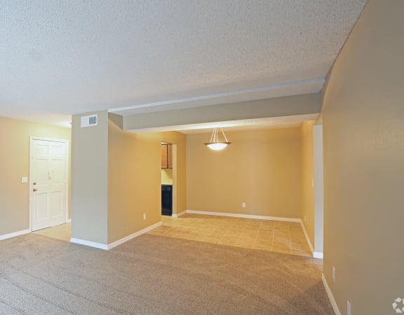 a large empty living room with a beige carpet at Foxcroft Apartments, Tampa, Florida, FL