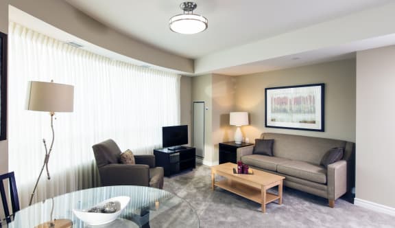 A living room with a couch, chair, coffee table, and TV. 