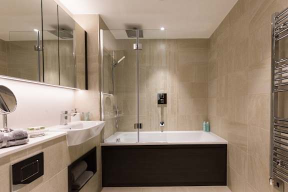 a bathroom with a tub and a sink and a mirror