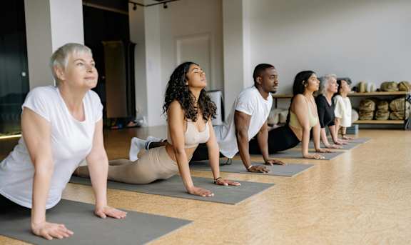 A group of people are practicing yoga in a room.