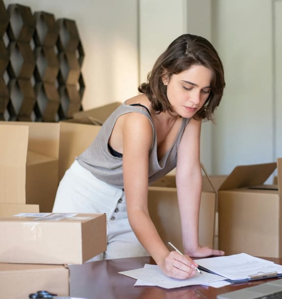 a woman working at a desk with boxes and a laptop