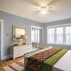 A bedroom with a bed, nightstands, and a ceiling fan.
