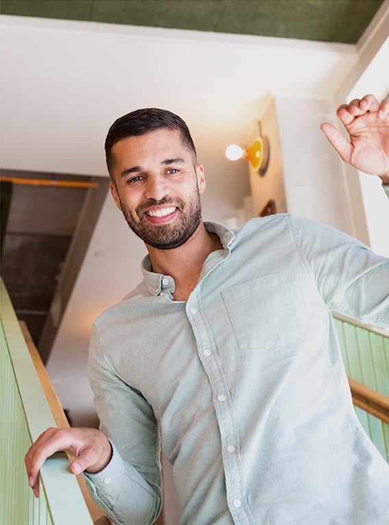 a man waving his hand on a staircase
