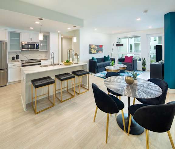 A modern kitchen with a bar area and a dining table set up.